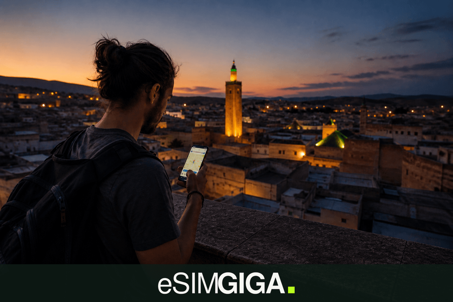 Traveller with an eSIM smartphone on a medina rooftop in Morocco at dusk, eSIM Giga banner